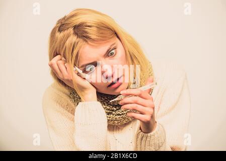 Mesurer la température. La fièvre de la pause des recours. La prise de température et d'évaluer les symptômes. Concept à haute température. Femme se sent gravement malade l'éternuement. Fille en tissu écharpe tenir thermomètre et close up. Banque D'Images