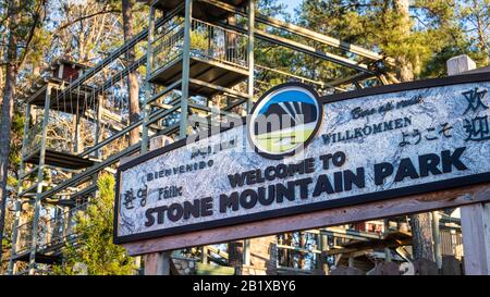 Signe de bienvenue au Stone Mountain Park à Atlanta, Géorgie avec parcours de cordes d'aventure en famille SkyHike en arrière-plan. (ÉTATS-UNIS) Banque D'Images