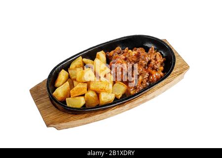 Pommes de terre avec viande, bœuf, agneau, goulash, friture, portion cuite sur une poêle à frire chaude, sur une planche en bois avec vue latérale sur fond blanc. Pour le menu Banque D'Images