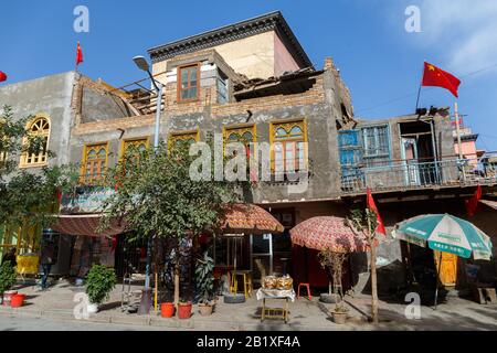 Maison Dans La Vieille Ville De Kashgar. Plusieurs drapeaux chinois sont placés sur les murs latéraux et sur le dessus du bâtiment. Capturé Pendant Les Fêtes Nationales Chinoises. Banque D'Images