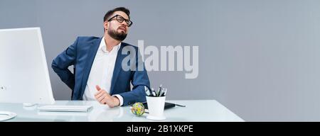 Homme D'Affaires Avec Douleur De Dos Maintenant Son Hip De Braconnage Banque D'Images