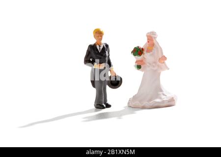 Mariage miniature avec une mariée et un marié dans un chapeau et queues de haut et une robe blanche debout ensemble sur blanc Banque D'Images