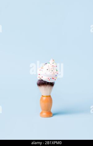 Brosse de rasage classique en bois avec mousse, yeux et confettis de bonbons, traitement pour le soin du corps, drôle concept d'épilation, idée créative minimale, bannière, Banque D'Images