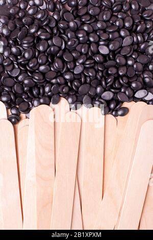 Cire en polymère de perle noire pour graines de grain et spatule en bois bâton pour la fermeture de l'épilation. Outils de concept od pour l'épilation, flyer, bannière, coupon, distante, Banque D'Images
