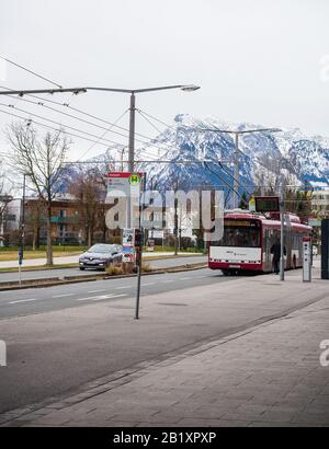 Salzbourg, Autriche-27 février 2020: Un arrêt de bus dans une rue avec des montagnes enneigées en arrière-plan Banque D'Images