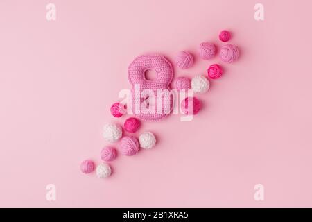 Joyeuses célébrations de la Journée internationale de la femme le 8 mars, CARTE de félicitations. Rose crochetage fait main Numéro huit et boule de fil, concept minimal pour soi Banque D'Images