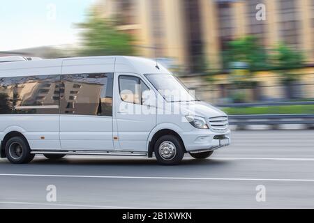 Minibus blanc va sur la ville street Banque D'Images