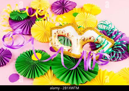 Confetti en papier coloré, masque carnivale et serpentine colorée sur un fond rose avec espace de copie, carte de vœux et modèle d'invitation de fête Banque D'Images