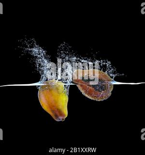 le fruit de la papaye qui tombe dans l'eau et crée des éclaboussures. fond noir personne autour. concept de fraîcheur et de nourriture naturelle. rendu tridimensionnel. Banque D'Images