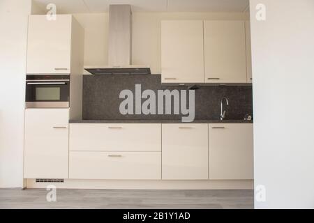 Cuisine moderne blanc en nouvelle maison vide avec plancher en bois Banque D'Images