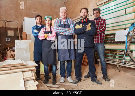 Carpenter avec des artisans et des apprentis dans sa menuiserie Banque D'Images