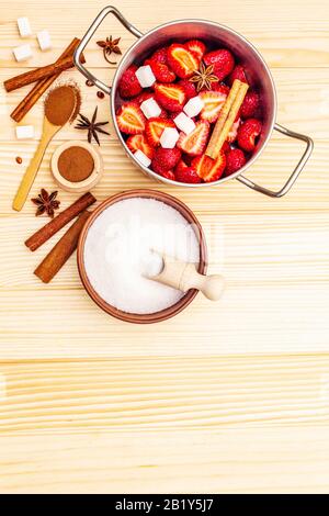Confiture de fraises. Ingrédients pour la fabrication de desserts sucrés faits maison. Concept de préservation de la maison. Baies fraîches, sucre, cannelle, anis étoilé. Planches en bois ba Banque D'Images