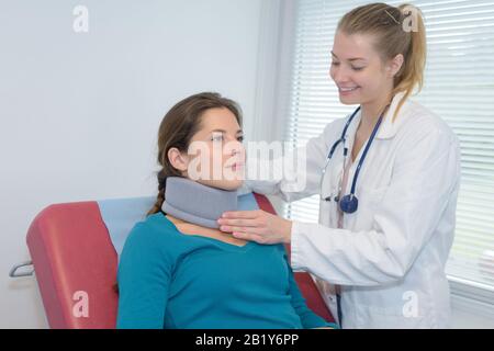 médecin mettant le soutien du cou du patient Banque D'Images