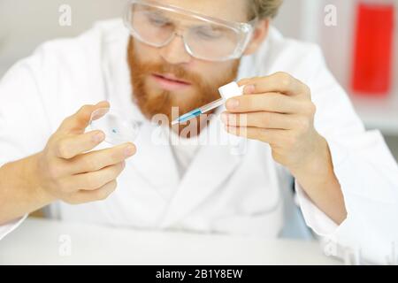 Jeune biologiste définit le séquençage d'Adn réaction avec pipette multicanaux Banque D'Images