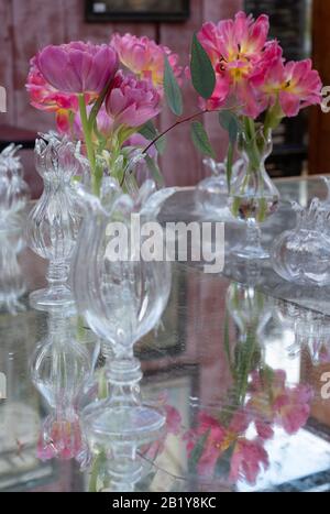 Table décorée de fleurs roses azalées dans des vases en cristal de verre. Banque D'Images
