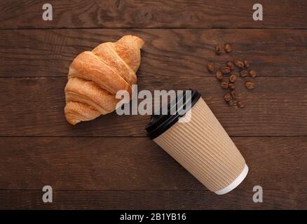 croissant grains de café en verre jetable sur fond en bois Banque D'Images