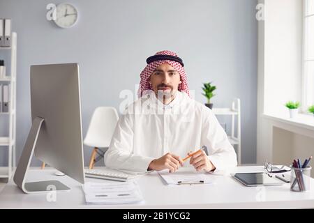 Un homme arabe calme est assis à une table dans le bureau. A Banque D'Images