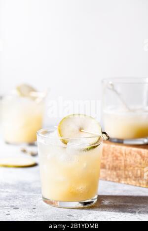 Un petit verre de mocktail ou de cocktail rafraîchissant à base de soda de poire sur fond de béton gris. Boisson estivale sans alcool. Mise au point sélective Banque D'Images