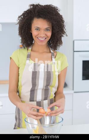 jeune femme sourit de la tarte à la cuisine Banque D'Images