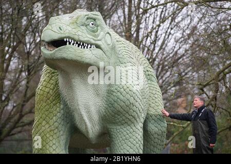 Simon Buteux de l'Angleterre historique avec une sculpture d'Iguanadon, qui fait partie des dinosaures du Crystal Palace, dans le Crystal Palace Park, Londres. Les statues de classe I de 30 ans, construites dans les années 1850, ont été ajoutées au registre du patrimoine historique de l'Angleterre à risque après que les experts ont trouvé de grandes fissures sur les corps et les membres et en danger de perdre des orteils, des dents et des queues. Banque D'Images