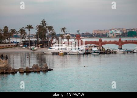 vue sur la mer du port avec palmiers et vieux pont pierreux montrant le complexe face au lagon Banque D'Images