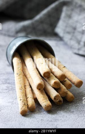 Gressins italiens traditionnels avec graines de lin sur fond gris. Banque D'Images