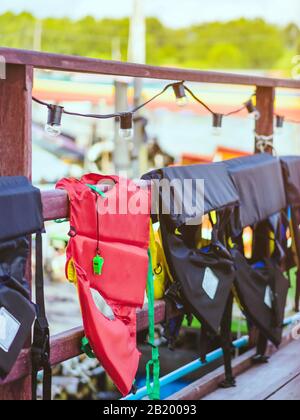 Un sifflet vert avec une veste de sauvetage rouge accrochée sur la rampe autour de la passerelle pour permettre aux passagers de se déplacer en toute sécurité sur les quais. Banque D'Images