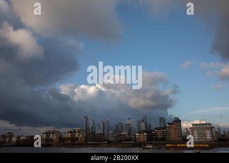 Vue sur la Tamise en direction de Canary Wharf et du quartier financier des Docklands car une barge de déchets est transportée par un petit bateau remorqueur le 5 novembre 2019 à Londres, Angleterre, Royaume-Uni. Canary Wharf est le deuxième quartier d'affaires central de Londres et est situé sur l'île de Dogs. C'est l'un des principaux centres financiers au monde, qui abrite de nombreux bâtiments les plus hauts, dont Le deuxième plus haut du Royaume-Uni, One Canada Square. Banque D'Images