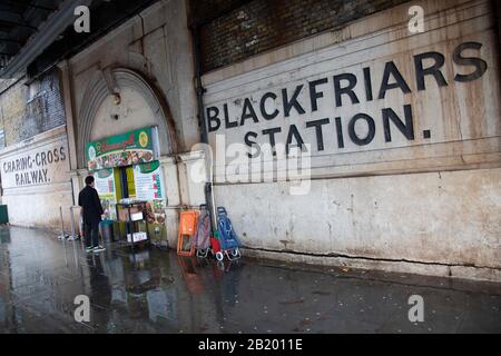 Les gens marchent devant de vieux panneaux pour la gare de Blackfriars, qui fait partie de la compagnie de chemin de fer Charing Cross le 27 novembre 2019 à Londres, Angleterre, Royaume-Uni. La compagnie de chemin de fer Charing Cross a été créée en 1859 afin de construire une extension reliant la gare de Waterloo. Banque D'Images