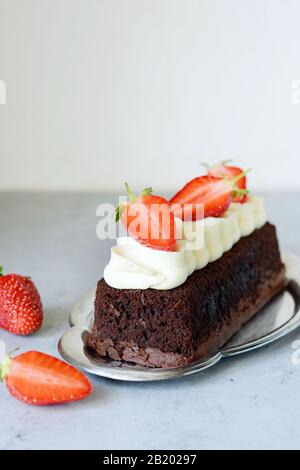 Brownie au chocolat avec crème à la vanille aérée et fraises fraîches. Gâteau au chocolat avec crème et baies fraîches. Thé dessert Banque D'Images