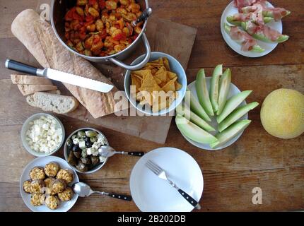 Table de cuisine avec nourriture, melon, gnocchi, olives, salade de feta et champignons Banque D'Images