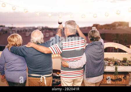 Les personnes âgées se réjouirent de s'amuser au barbecue sur le toit - dîner En famille Avec Des verres à vin rouge au barbecue sur la terrasse Banque D'Images