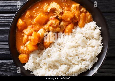 Domoda est le plat national de Gambie, un ragoût d'arachide fait de citrouille de viande et servi sur le riz moelleux près dans une assiette sur la table. T horizontal Banque D'Images