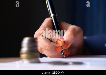 Gros plan de la main des femmes avec l'écriture au stylo sur papier Banque D'Images