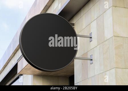 Panneau unique rond ou signalisation sur le mur de marbre avec maquette de panneau noir vierge. Vue de dessous Banque D'Images