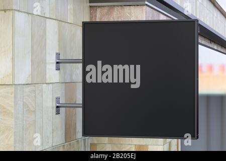 Panneau unique carré ou signalisation sur le mur en marbre avec maquette de panneau noir vierge. Vue latérale Banque D'Images