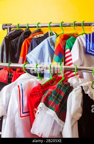 Rack avec de nombreux costumes de vacances pour les enfants sur les cintres au salon de mode enfants. Service de location dans la boutique de tissus. Banque D'Images