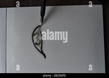 Séquence de dessins, Trempez le stylo avec l'encre de l'inde sur du papier d'aquarelle humide d'un oeil Banque D'Images
