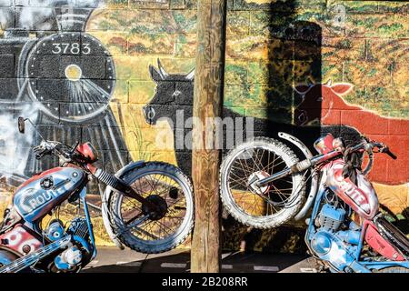 Extérieur du chariot de cuivre, Seligman, Arizona, États-Unis. Panneau historique de la route 66 et fresque murale pittoresque sur le mur avec motos en béton Banque D'Images