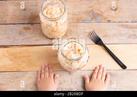 les mains des enfants et les légumes fermentés dans le pot, repas sain Banque D'Images