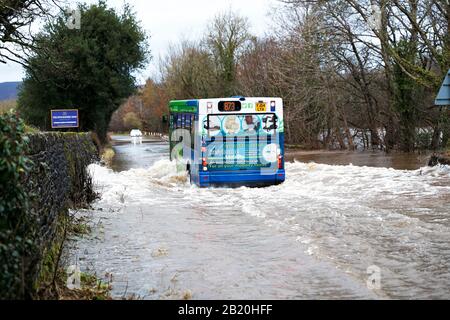 Un bus circule le long d'une route inondée où la rivière Wharfe a fait éclater ses rives dans le Yorkshire de l'Ouest Addingham pendant la tempête Dennis 09-02-20 Banque D'Images