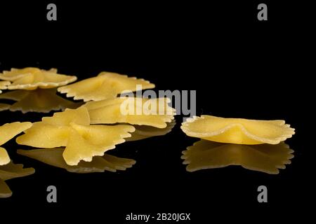 Groupe de six pâtes jaunes farfalle isolées sur verre noir Banque D'Images