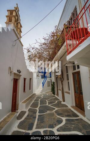 Rue Pavée étroite sur l'île de Mykonos avec bâtiments architecturaux traditionnels, maisons, boutiques, cafétérias et églises pendant une saison non touristique. Banque D'Images