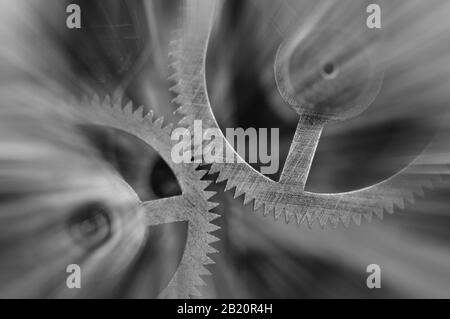 Photographie noir et blanc. Roues À Crémaillère en métal dans le mécanisme de l'horloge , poutres solaires abstraites, concept Movement est la vie, travail d'équipe , Idea Technology, Infinity, Banque D'Images