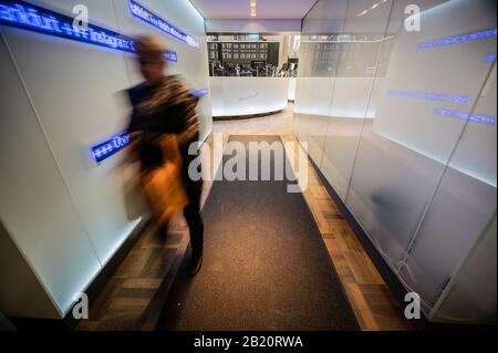 Francfort, Allemagne. 28 février 2020: Une femme quitte le plancher commercial. Le principal indice allemand, le DAX, est en déclin. La baisse du prix de l'action due à des préoccupations concernant une pandémie de coronavirus a atteint un pic temporaire vendredi avec une perte de Dax parfois plus de 5 pour cent. Cependant, l'indice allemand de référence a légèrement récupéré en fin de négociation, en fermant 3,86 pour cent à 11 890,35 points. Avec une baisse de 12,44 pour cent en fin de compte depuis vendredi dernier, les investisseurs ont néanmoins connu la semaine la plus noire depuis le krach boursier en août 2011. Photo: Andreas Arnold/dpa/Alay Live news Cre Banque D'Images