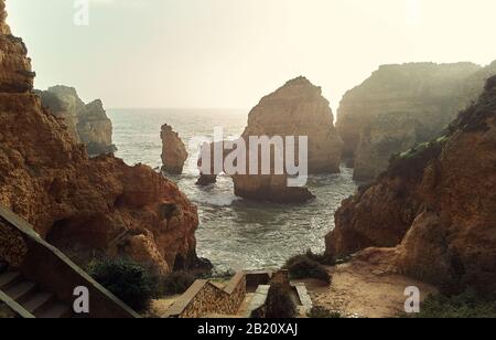 Vue sur le promontoire de Ponta da Piedade avec groupe de formations rocheuses falaises jaunes-dorées le long de la côte calcaire, ville de Lagos, Portugal Banque D'Images