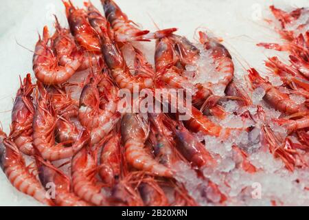 Photo de stock d'un gros tas de crevettes rouges sur une base de glace dans un marché de décrochage Banque D'Images