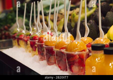 Faites le plein de photos d'un groupe de tasses en plastique avec des morceaux de délicieux fruits frais prêts à manger. Mise au point sélective Banque D'Images