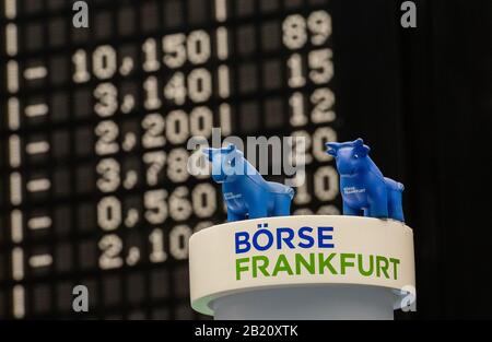 Francfort, Allemagne. 28 février 2020. Les taureaux miniatures se trouvent devant le tableau de bord. Un tableau indique les modifications apportées à l'index DAX principal. Le principal indice allemand, le DAX, est en déclin. La baisse du prix de l'action due à des préoccupations concernant une pandémie de coronavirus a atteint un pic temporaire vendredi avec une perte de Dax parfois plus de 5 pour cent. Cependant, l'indice allemand de référence a légèrement récupéré en fin de négociation, en fermant 3,86 pour cent à 11 890,35 points. Avec une baisse de 12,44 pour cent en fin de compte depuis vendredi dernier, les investisseurs ont néanmoins connu la semaine la plus noire depuis la bourse de mars Banque D'Images