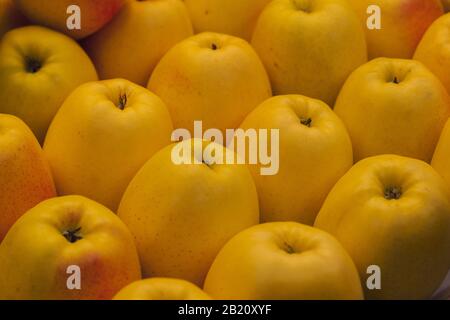 Stock photo d'un gros plan d'une pile de délicieuses pommes jaunes dans un marché de décrochage Banque D'Images